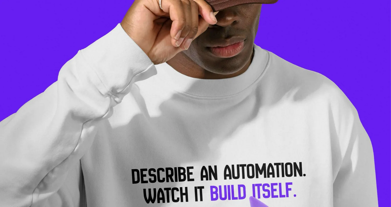 A white sweatshirt printed with “Describe an automation. Watch it build itself.” on an Electric Indigo background.